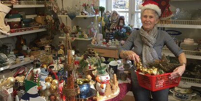 Freiwillig engagiert im Team des FAIRKAUF-Ladens: Gabi Stölting befüllt beispielhaft einen Einkaufskorb mit Advents- und Weihnachtsartikeln.