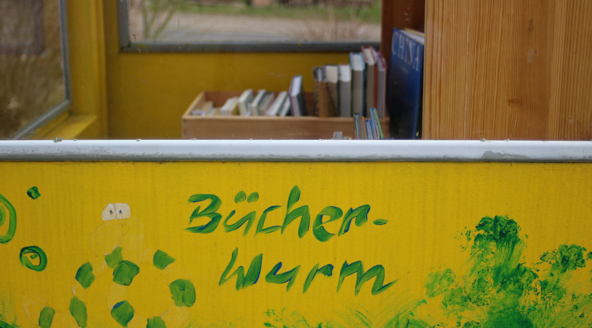 Ausschnitt der Bücherzelle mit der Aufschrift "Bücherwurm"