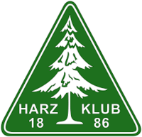 Harzklub Logo mit weißer Tanne auf grünem Dreieck.