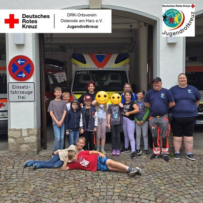 Das Bild zeigt eine Gruppe junger Menschen bei einer Ferienpass-Aktion vor dem DRK-Depot.