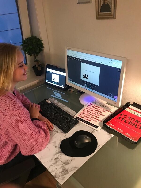 Studentin sitzt für eine Online-Treffen vor einem Computer