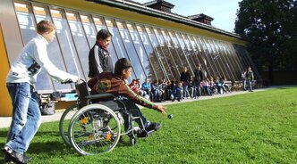 Kind im Rollstuhl spielt auf einem Sportplatz (Bild von Stefan Schranz auf Pixabay)