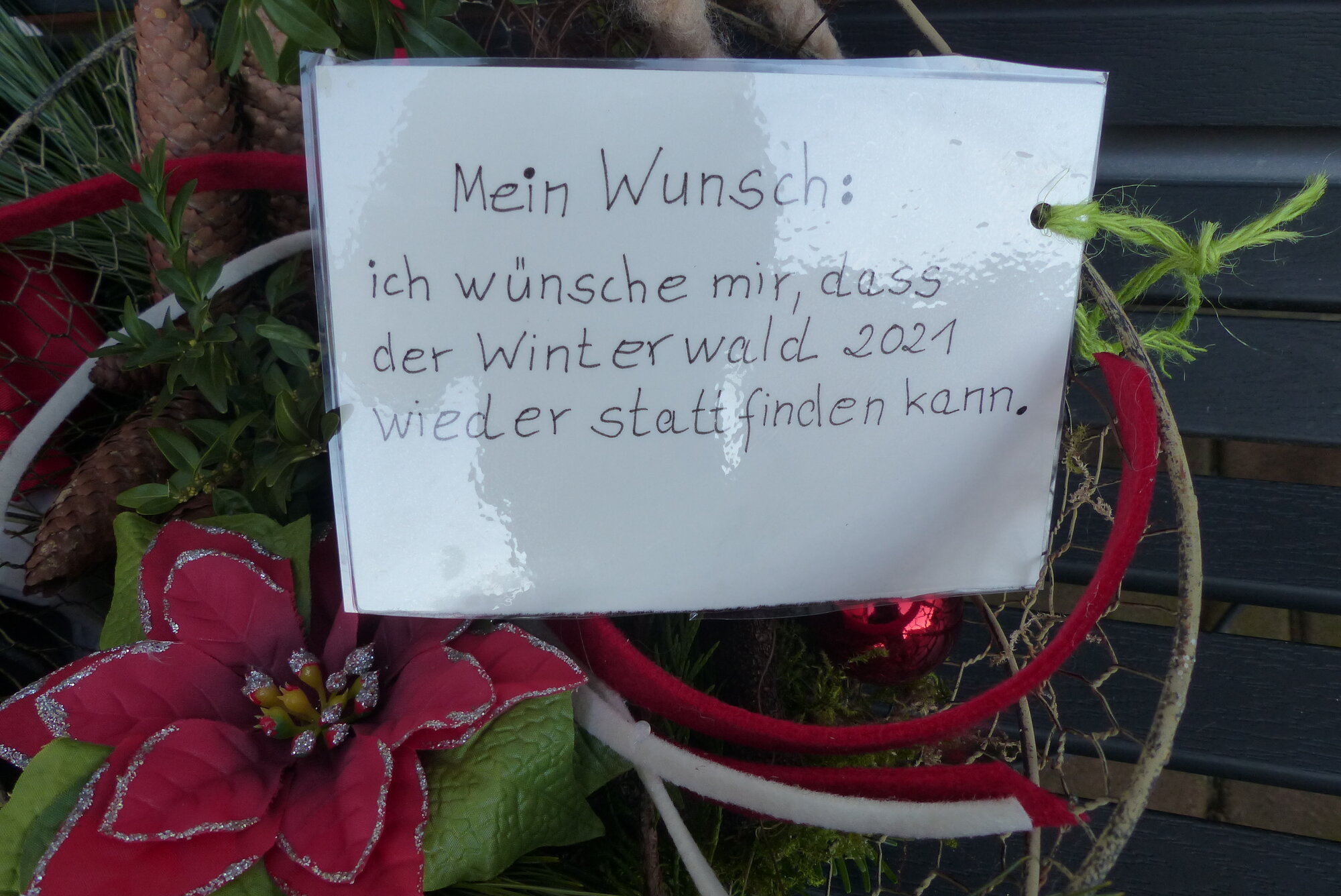 laminierter Zettel an Weihnachtsgesteck