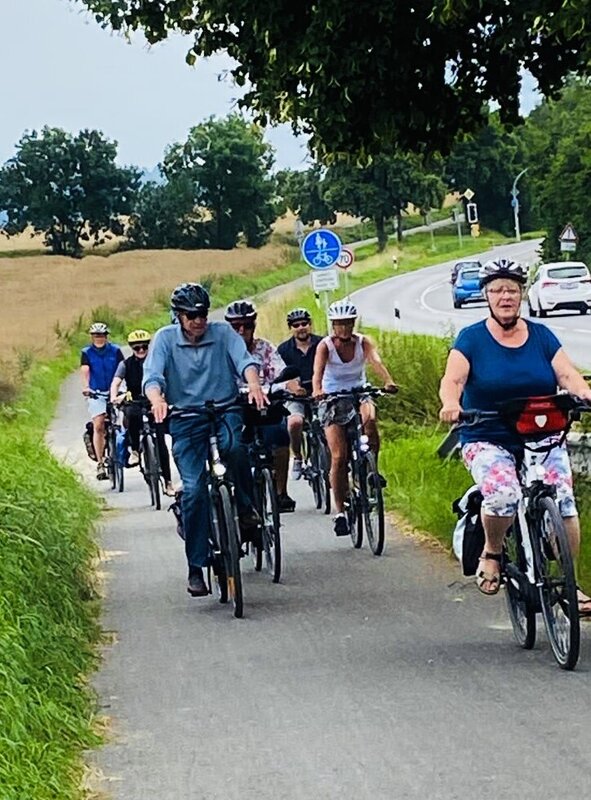 Eine Gruppe Radfahrer*innen auf einem Radweg.