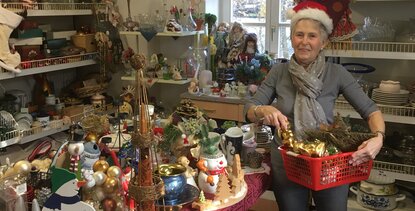 Freiwillig engagiert im Team des FAIRKAUF-Ladens: Gabi Stölting befüllt beispielhaft einen Einkaufskorb mit Advents- und Weihnachtsartikeln.