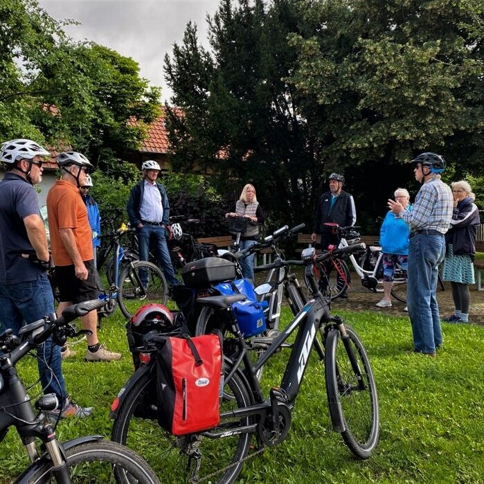 Meschen stehen zusammen und tragen Fahrradhelme.