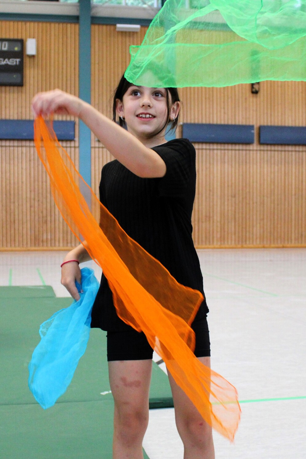 Zirkuskünste: Mädchen jongliert mit bunten Tüchern.