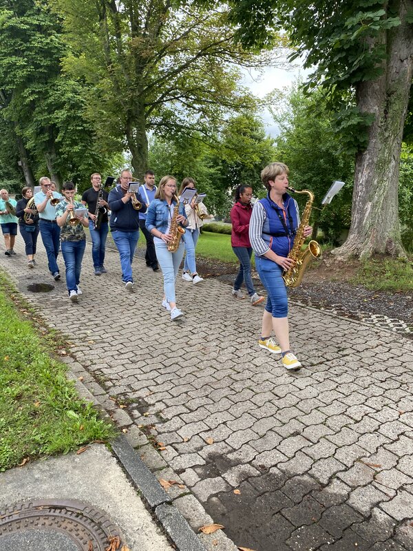 Spielmannzug marschiert über gepflasterten Weg